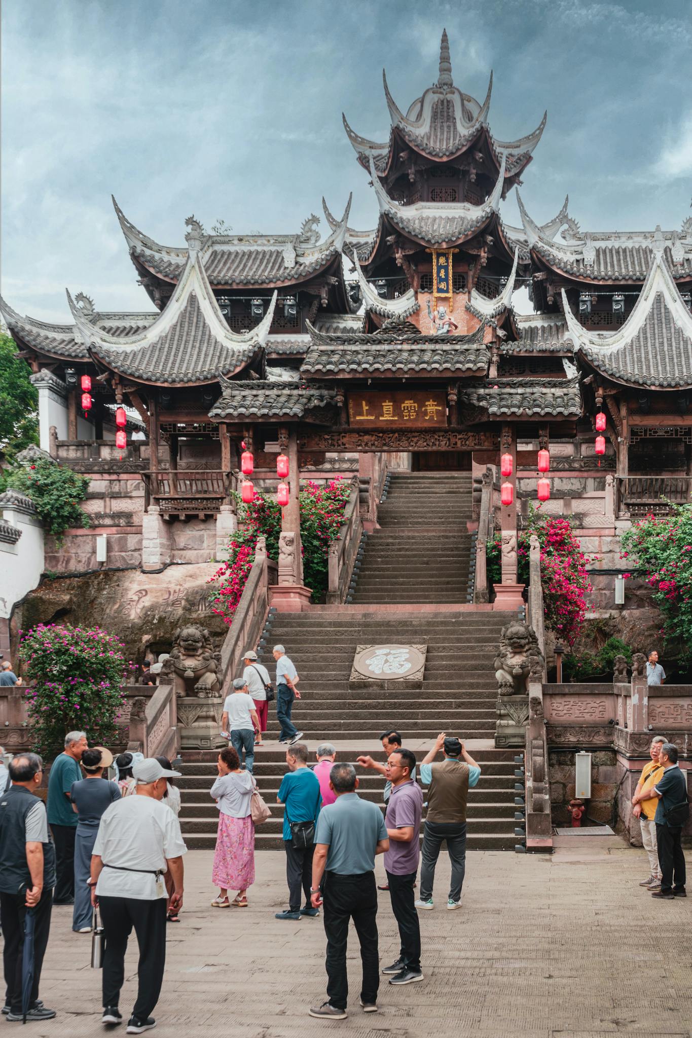 A group of tourists visiting a traditional Asian temple with ornate architecture and vibrant lanterns.