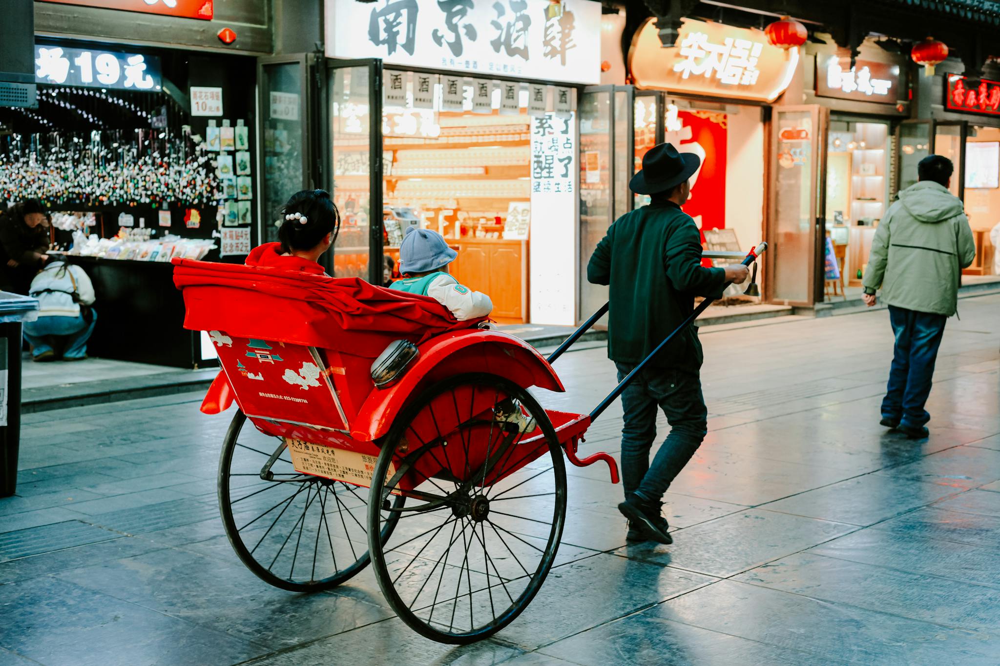 A vibrant street scene in Nanjing featuring a traditional rickshaw ride, blending modern shops with cultural heritage.